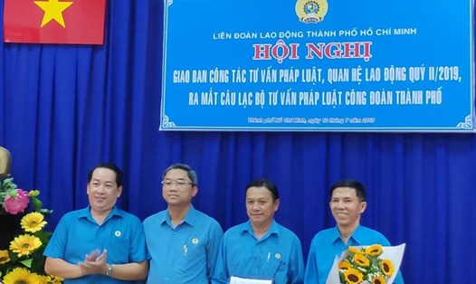 Ông Kiều Ngọc Vũ (bên trái), Phó Chủ tịch LĐLĐ TPHCM, tặng hoa Ban Chủ nhiệm Câu lạc bộ Tư vấn Pháp luật Công đoàn.