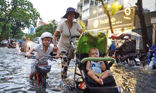 Người dân ở "khu nhà giàu" Thảo Điền bì bõm lội nước sau cơn mưa.  Ảnh: M.Q