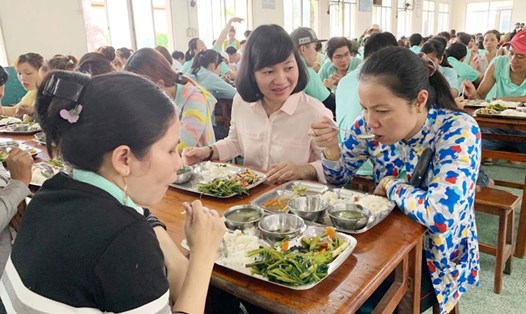 Cùng ăn bữa cơm với công nhân là cách chị Trương Thị Bích Hạnh (thứ hai từ phải qua) chia sẻ và lắng nghe tâm tư tình cảm của chị em. Ảnh: L.T