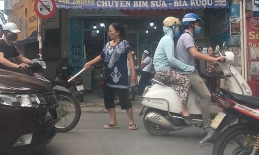 Người phụ nữ phân luồng giao thông trên đường Đê La Thành (Hà Nội). Ảnh: Nguyen Quoc Hai