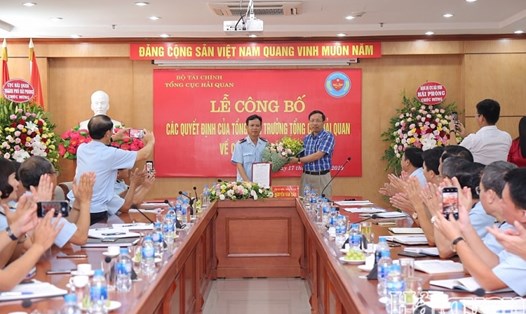 Tổng cục trưởng Nguyễn Văn Cẩn trao quyết định, tặng hoa chúc mừng ông Nguyễn Duy Ngọc. Ảnh: Báo Hải quan.