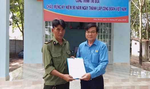 Chủ nhiệm UBKT Liên đoàn Lao động tỉnh Nguyễn Văn Sang trao quyết định tặng nhà mái ấm công đoàn cho đoàn viên Điểu Lưng.