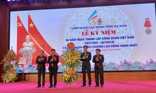 Phó Chủ tịch Tổng LĐLĐVN Ngọ Duy Hiểu (thứ hai từ phải sang) tặng hoa chúc mừng LĐLĐ tỉnh Hà Nam. Ảnh: Thu Lệ