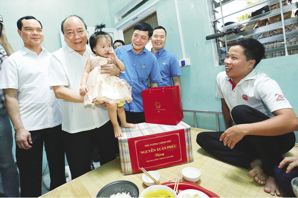 Thủ tướng Chính phủ Nguyễn Xuân Phúc (thứ 2 từ trái sang), Uỷ viên T.Ư Đảng, Chủ tịch Tổng LĐLĐVN Bùi Văn Cường (thứ 3 từ trái sang) và Uỷ viên T.Ư Đảng, Bí thư Tỉnh uỷ Hà Nam Nguyễn Đình Khang (trái, ảnh) động viên, tặng quà gia đình người lao động đang thuê trọ tại thôn Thần Nữ, xã Bạch Thượng, huyện Duy Tiên, tỉnh Hà Nam. Ảnh: HẢI NGUYỄN