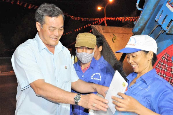 Chủ tịch LĐLĐ tỉnh Bình Phước Nguyễn Hồng Trà tặng quà công nhân 
vệ sinh môi trường đêm giao thừa. Ảnh: LĐLĐ Bình Phước cung cấp