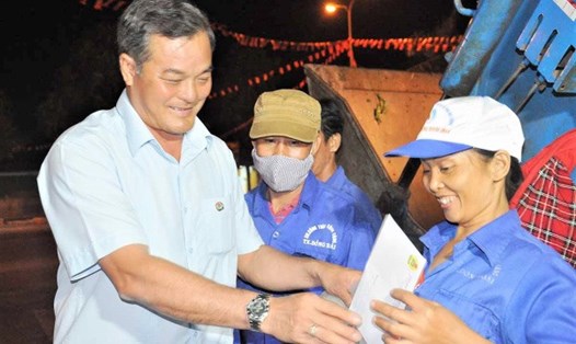 Chủ tịch LĐLĐ tỉnh Bình Phước Nguyễn Hồng Trà tặng quà công nhân 
vệ sinh môi trường đêm giao thừa. Ảnh: LĐLĐ Bình Phước cung cấp