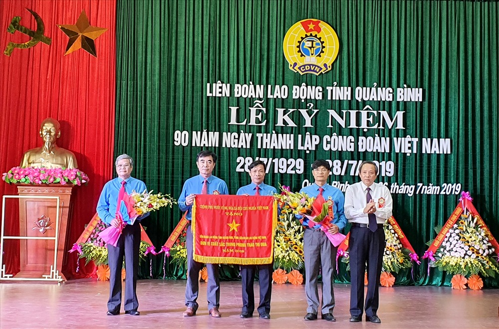 Bí thư Tỉnh ủy Quảng Bình Hoàng Đăng Quang trao Cờ xuất sắc của Chính phủ cho Công đoàn tỉnh Quảng Bình. Ảnh: Lê Phi Long