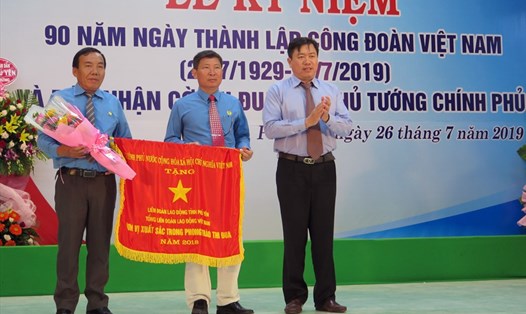Ông Trần Hữu Thế - Phó Chủ tịch UBND tỉnh Phú Yên (phải) trao cờ thi đua xuất sắc của Thủ tướng Chính phủ cho LĐLĐ tỉnh. Ảnh: PV
