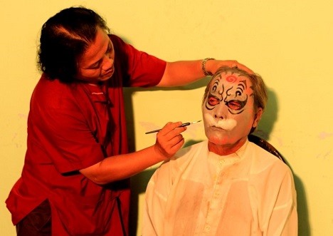 Nghệ nhân La Thanh Hùng vẽ mặt cho diễn viên trong nhà hát.  Ảnh: NVCC