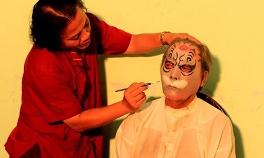 Nghệ nhân La Thanh Hùng vẽ mặt cho diễn viên trong nhà hát.  Ảnh: NVCC