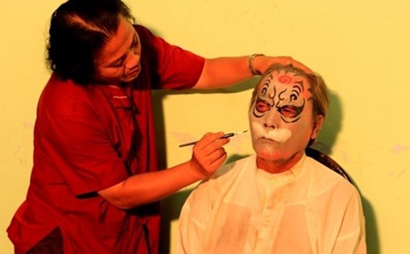 Nghệ nhân La Thanh Hùng vẽ mặt cho diễn viên trong nhà hát.  Ảnh: NVCC