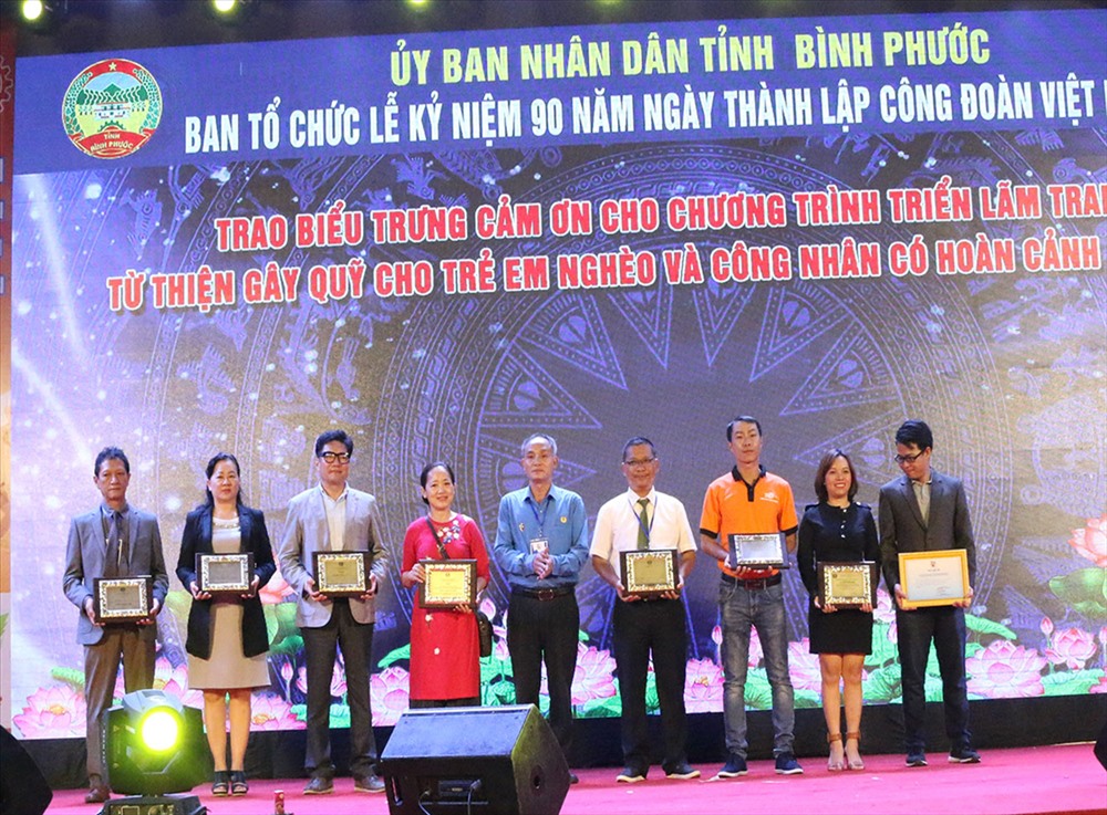 Ông Đỗ Thành Lai, Phó Chủ tịch Liên đoàn Lao động tỉnh Bình Phước trao Biểu trưng cảm ơn cho Chương trình triển lãm tranh từ thiện gây quỹ cho trẻ em nghèo và công nhân có hoàn cảnh khó khăn Trong Lễ khai mạc Tuần Lễ đồng hành cùng đoàn viên công đoàn.