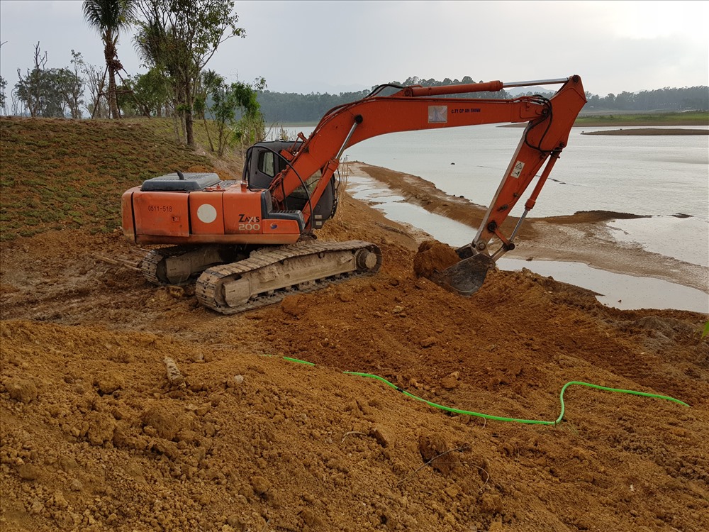 Tại khu đất đồi Mơ, máy xúc đang múc đất đã lấp xuống hồ Đồng Mô. Ảnh: NGUYÊN CHÍ