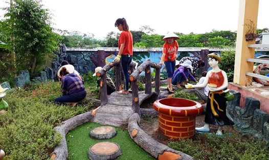 Đoàn viên CĐCS Trường mầm non xã Thạch Bình (huyện Nho Quan) 
tham gia trồng vườn hoa và làm sân chơi cho học sinh. Ảnh: P.V