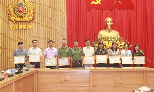 Đại tá Nguyễn Duy Toan - Bí thư Đảng ủy, Cục trưởng Cục công nghiệp an ninh (thứ 5 từ trái sang) trao giấy khen cho các tập thể, cá nhân. Ảnh: Vũ Linh