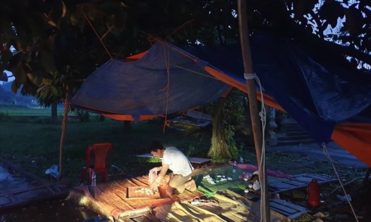 Người dân dỡ lều bạt đường vào bãi rác Nam Sơn. Ảnh P.Đông