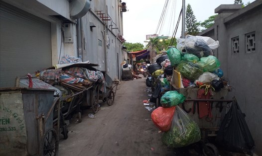 Hàng dài các xe chất đầy rác được tập kết trong một con ngõ trên đường Dương Quảng Hàm chờ để được cẩu đi. Ảnh PV