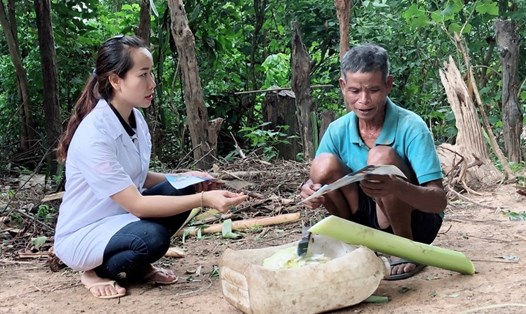 Cán bộ Trung tâm Y tế huyện Hướng Hóa tuyên truyền người dân diệt lăng quăng, loại bỏ nơi sinh sản của muỗi. Ảnh: Hưng Thơ.