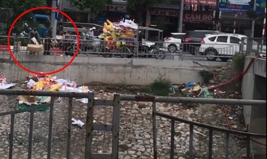 Hình ảnh người đàn ông chút rác xuống dòng sông Tô Lịch. Ảnh cắt từ Clip