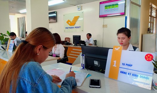 Nhân viên Bưu điện huyện Tam Nông đón tiếp khách hàng thực hiện các thủ tục hành chính.