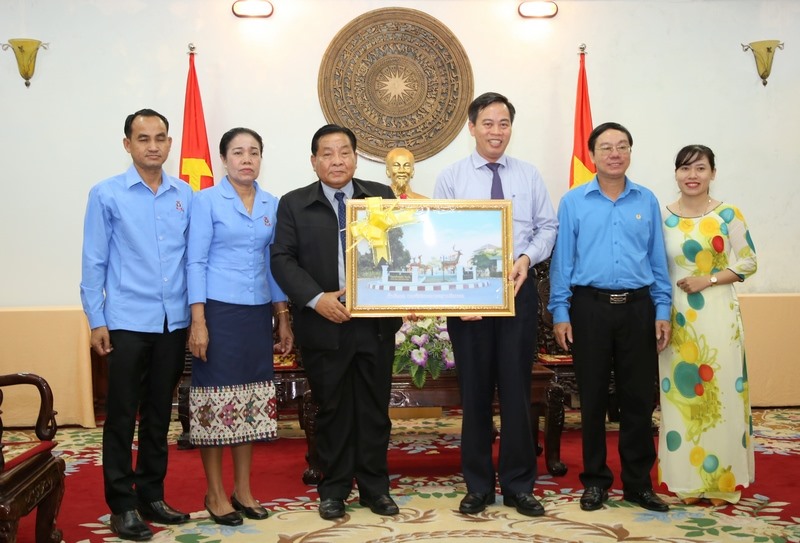 Ông Nguyễn Đăng Quang (thứ 3, từ phải sang) - Phó Bí thư Thường trực Tỉnh ủy Quảng Trị nhận món quà của ông Bun Liêng Chăn Văn Pheng (thứ 3, từ trái sang)- Chủ tịch LHCĐ tỉnh Savannakhet. Ảnh: Hưng Thơ.
