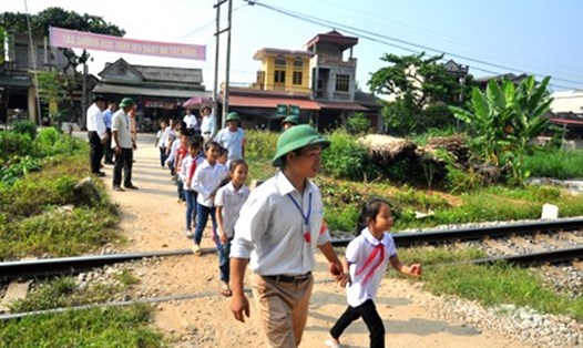 Tổ tự quản ATGT xã Đào Thịnh, huyện Trấn Yên, Yên Bái hướng dẫn học sinh qua điểm giao cắt giữa đường bộ và đường sắt.