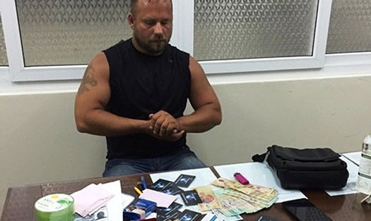 Một công dân Nga bị bắt quả tang sử dụng thẻ giả để rút tiền. Tang vật thu được gồm hàng trăm thẻ giả. Ảnh: PV