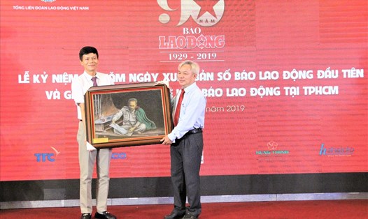 Tổng Biên tập Báo Lao Động Nguyễn Ngọc Hiển (bên trái) nhận quà lưu niệm do ông Dương Thế Trung, Phó Trưởng Ban Tuyên giáo Thành ủy TPHCM, trao tặng. Ảnh Đình Trọng