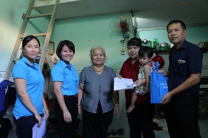 Bà Nguyễn Hoàng Bảo Trân (thứ 2, bên trái sang) trao tiền hỗ trợ cho gia đình chị Nguyễn Thị Kiều.