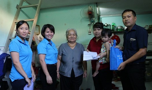 Bà Nguyễn Hoàng Bảo Trân (thứ 2, bên trái sang) trao tiền hỗ trợ cho gia đình chị Nguyễn Thị Kiều.