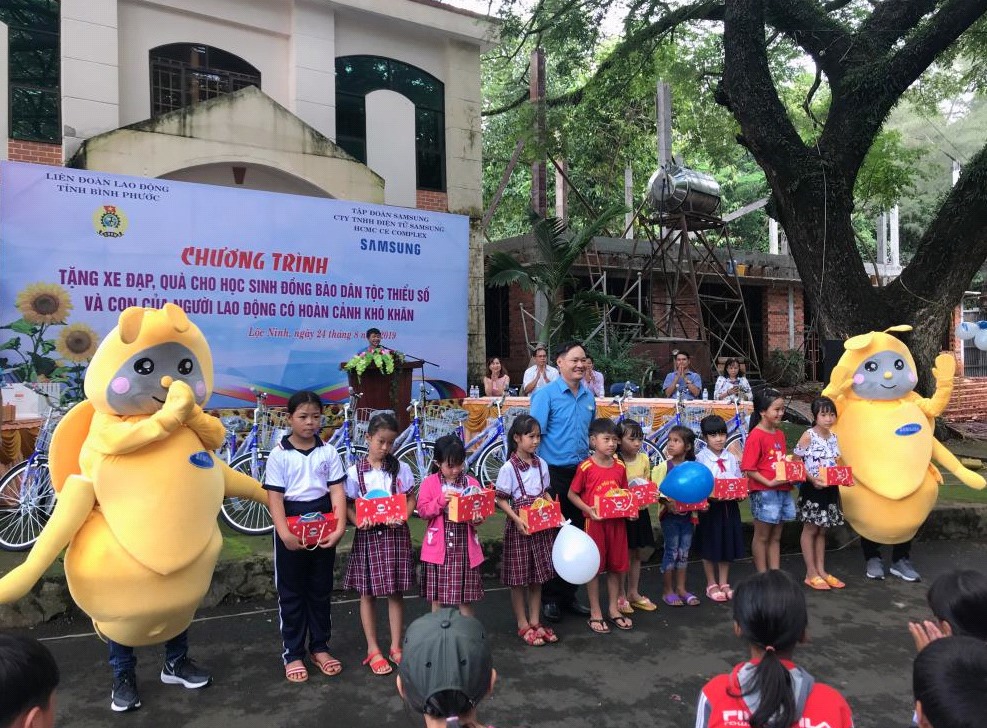 Ông Mạc Đình Huấn - Phó Chủ tịch LĐLĐ tỉnh Bình Phước trao quà và xe đạp cho các em.