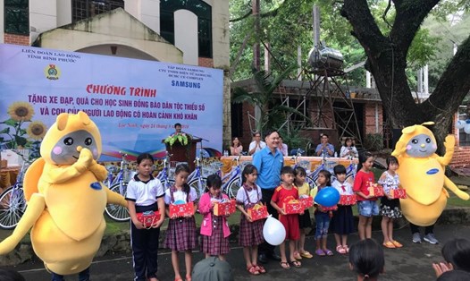 Ông Mạc Đình Huấn - Phó Chủ tịch LĐLĐ tỉnh Bình Phước trao quà và xe đạp cho các em.