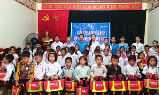 Lãnh đạo LĐLĐ tỉnh Điện Biên và Ngân hàng BIDV trao tặng phao cứu sinh cho học sinh tiểu học vùng lũ. Ảnh: N.Cường