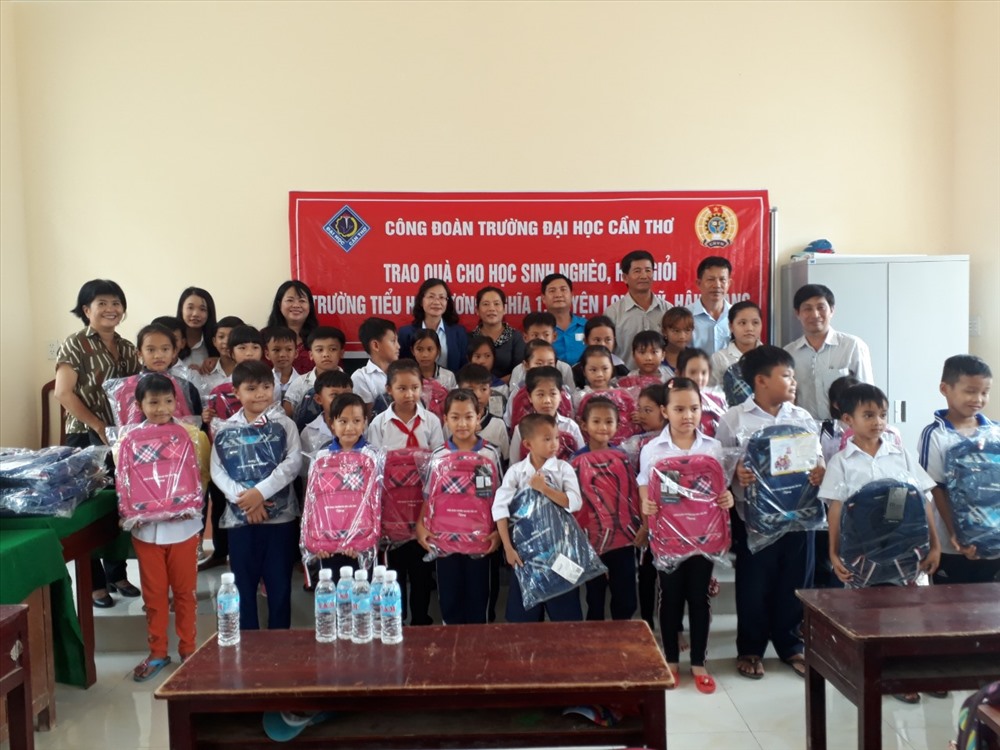 Lãnh đạo LĐLĐ tỉnh Hậu Giang và Công đoàn Trường Đại học Cần Thơ trao quà cho các em học sinh. Ảnh: Hoài Phúc