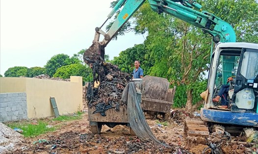 Ủy ban nhân dân xã Quang Hưng khắc phục việc chôn rác ở thân đê làm ô nhiễm nước sông. Ảnh: QTL.
