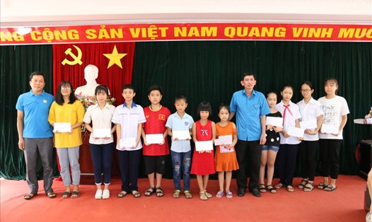 Đồng chí  Nguyễn Văn Chung – Tỉnh ủy viên, Chủ tịch Liên đoàn Lao động tỉnh (đứng thứ 5 từ bên phải sang) trao học bổng cho các cháu.