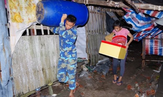 Lực lượng Biên phòng giúp dân di dời nhà tại Thị trấn Sông Đốc, huyện Trần Văn Thời đêm 3.8. Ảnh Lê Khoa