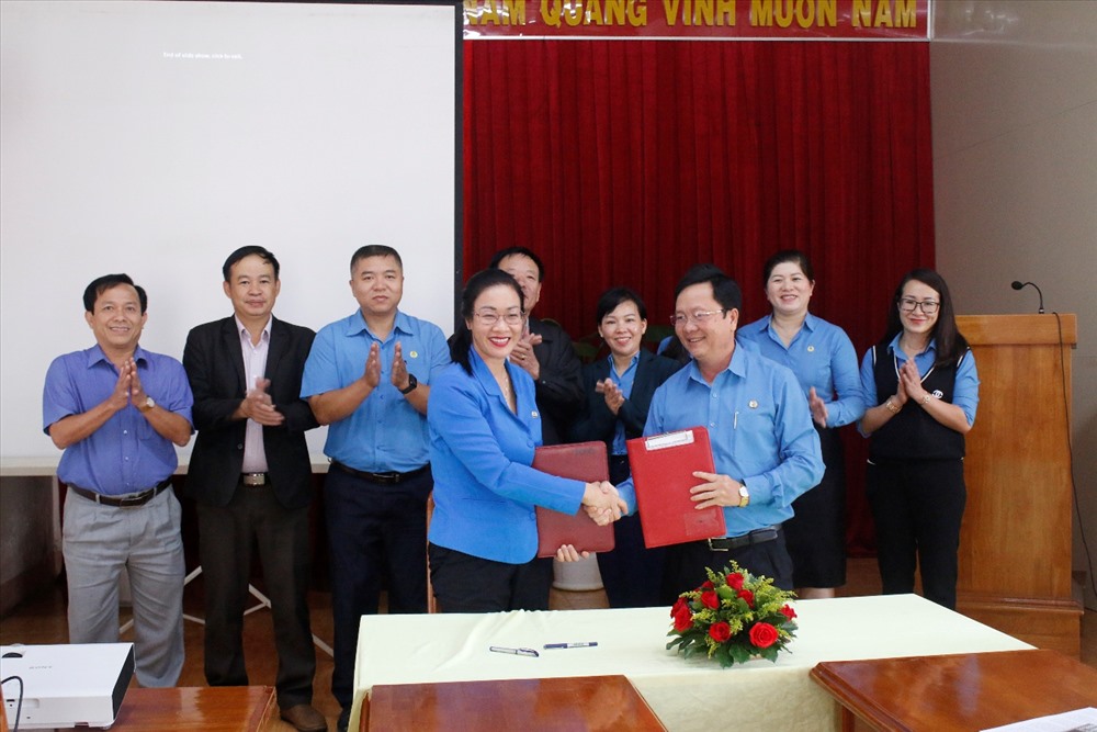 Lãnh đạo 2 đơn vị trao nhau bản kế hoạch ký kết.