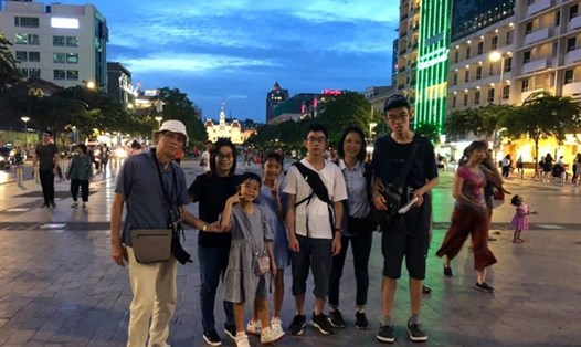Cụ Oki cùng con cháu chụp hình lưu niệm tại phố đi bộ Nguyễn Huệ. Ảnh: NVCC/Thanh Niên