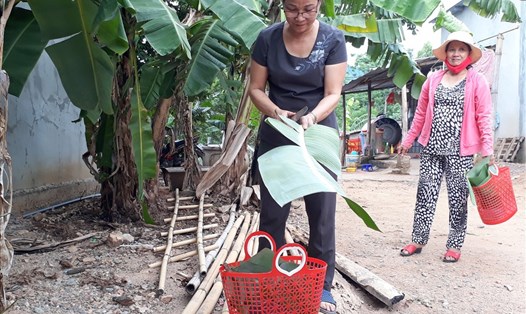 Hội viên phụ nữ tại thôn Long Phụng dùng giỏ nhựa, hộp nhựa và lá chuối khi đi chợ. Ảnh: HT.