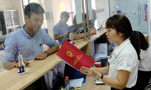 Hướng dẫn cho người dân làm thủ tục hành chính tại Bộ phận một cửa UBND huyện Sóc Sơn. Ảnh: Kinh tế đô thị
