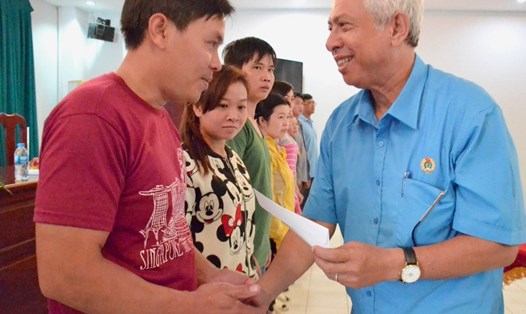 Chủ tịch LĐLĐ An Giang Nguyễn Thiện Phú (phải) trao quà cho CNLĐ đang làm việc tại Cty CP Agifish. Ảnh: LỤC TÙNG
