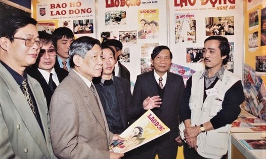 Nhà báo Lê Quang Vinh (phải, ảnh) cùng các cán bộ, phóng viên Báo Lao Động đón tiếp Tổng Bí thư Lê Khả Phiêu thăm gian trưng bày của hệ thống báo chí Công đoàn tại một Hội Báo Xuân.