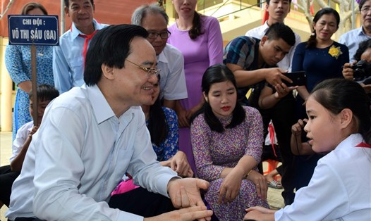 Bộ trưởng Phùng Xuân Nhạ thăm hỏi, động viên học sinh vùng lũ Tân Hóa. Ảnh: LPL