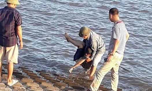 Người dân vớt thi thể cháu bé bị đuối nước. Ảnh NDCC