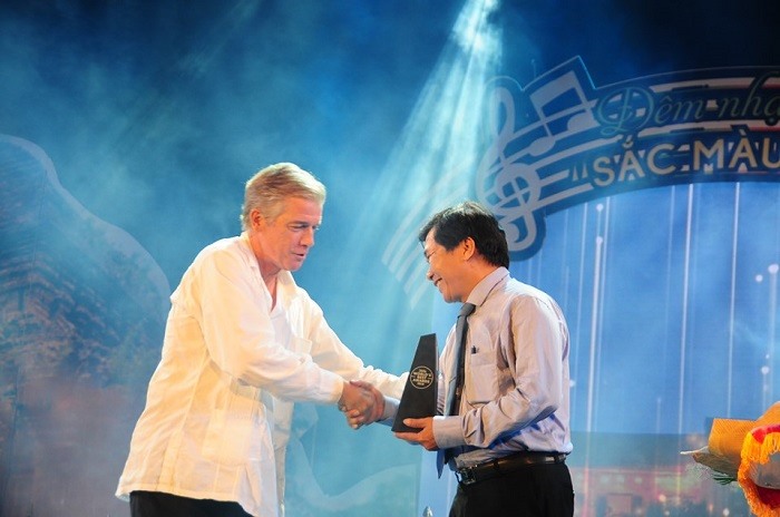 Đại diện Tạp chí Travel & Leisure (bìa trái) trao biểu tượng danh hiệu cho lãnh đạo TP.Hội An