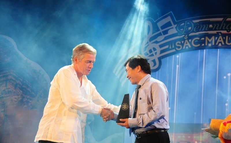 Đại diện Tạp chí Travel & Leisure (bìa trái) trao biểu tượng danh hiệu cho lãnh đạo TP.Hội An