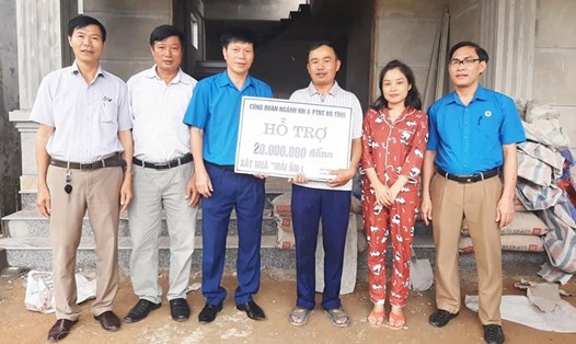 Ông Nguyễn Quang Thái - Chủ tịch Công đoàn ngành Nông nghiệp và Phát triển nông thôn Hà Tĩnh trao tiền hỗ trợ làm nhà Mái ấm công đoàn cho gia đình anh Hội. Ảnh: NM