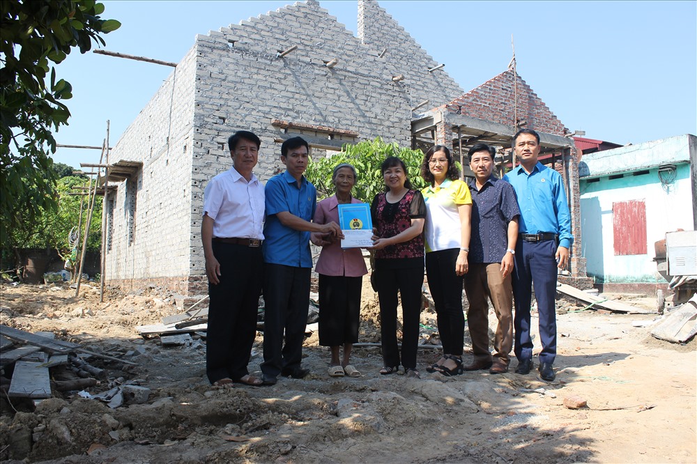 Các đồng chí lãnh đạo, nguyên lãnh đạo LĐLĐ tỉnh Bắc Giang, Liên đoàn Lao động huyện Lục Nam trao tiền hỗ trợ gia đình bà Lương Thị Bảy.