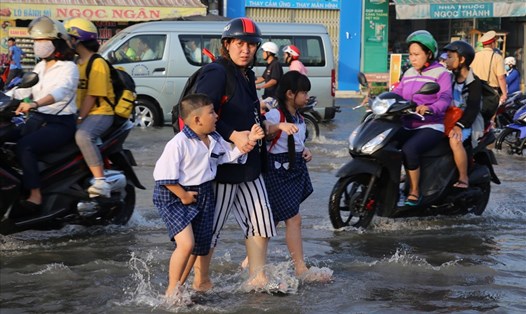Học sinh lội nước đến trường do đường bị ngập trong sáng 30.9 tại TP. Cần Thơ. Ảnh: Hưng Thơ.